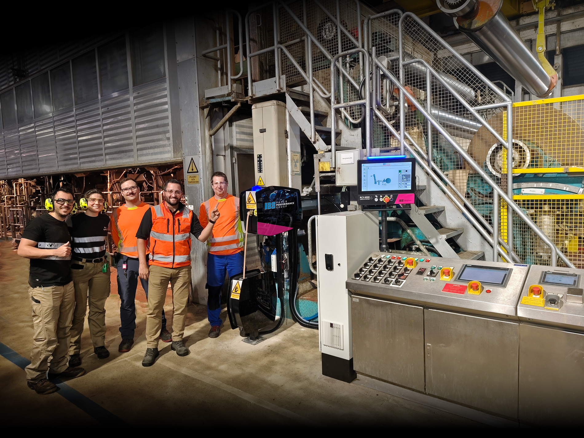 Mitarbeiter von IBS Performance Group stehen in einer Produktionshalle in Österreich vor Maschinen.